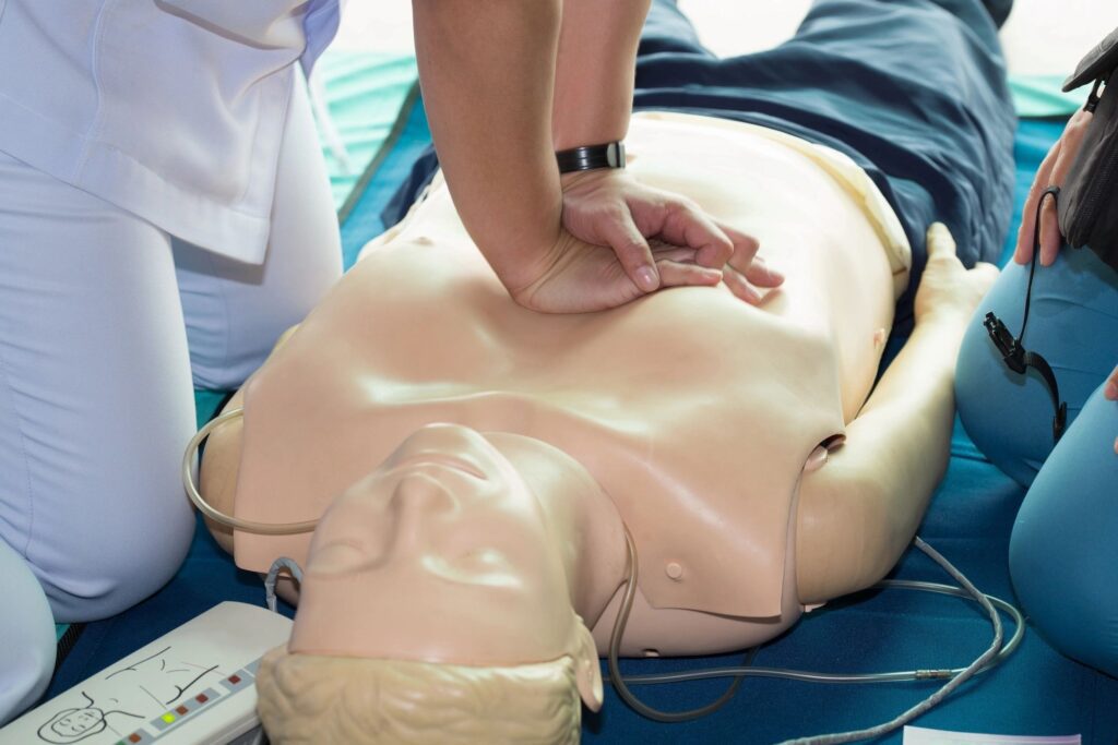 A person is performing cpr on an infant dummy.