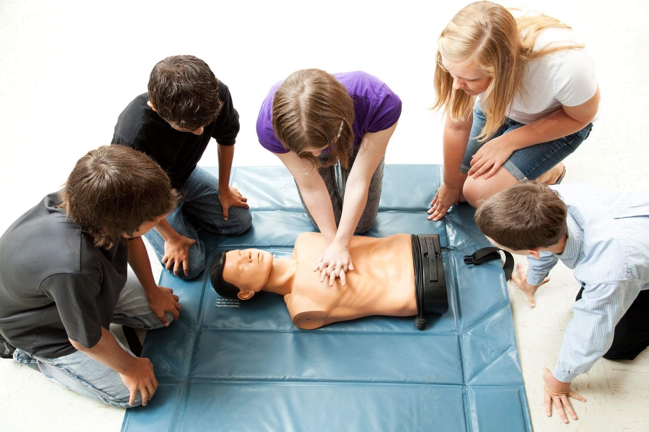 Students practicing CPR chest compressions on mannequin