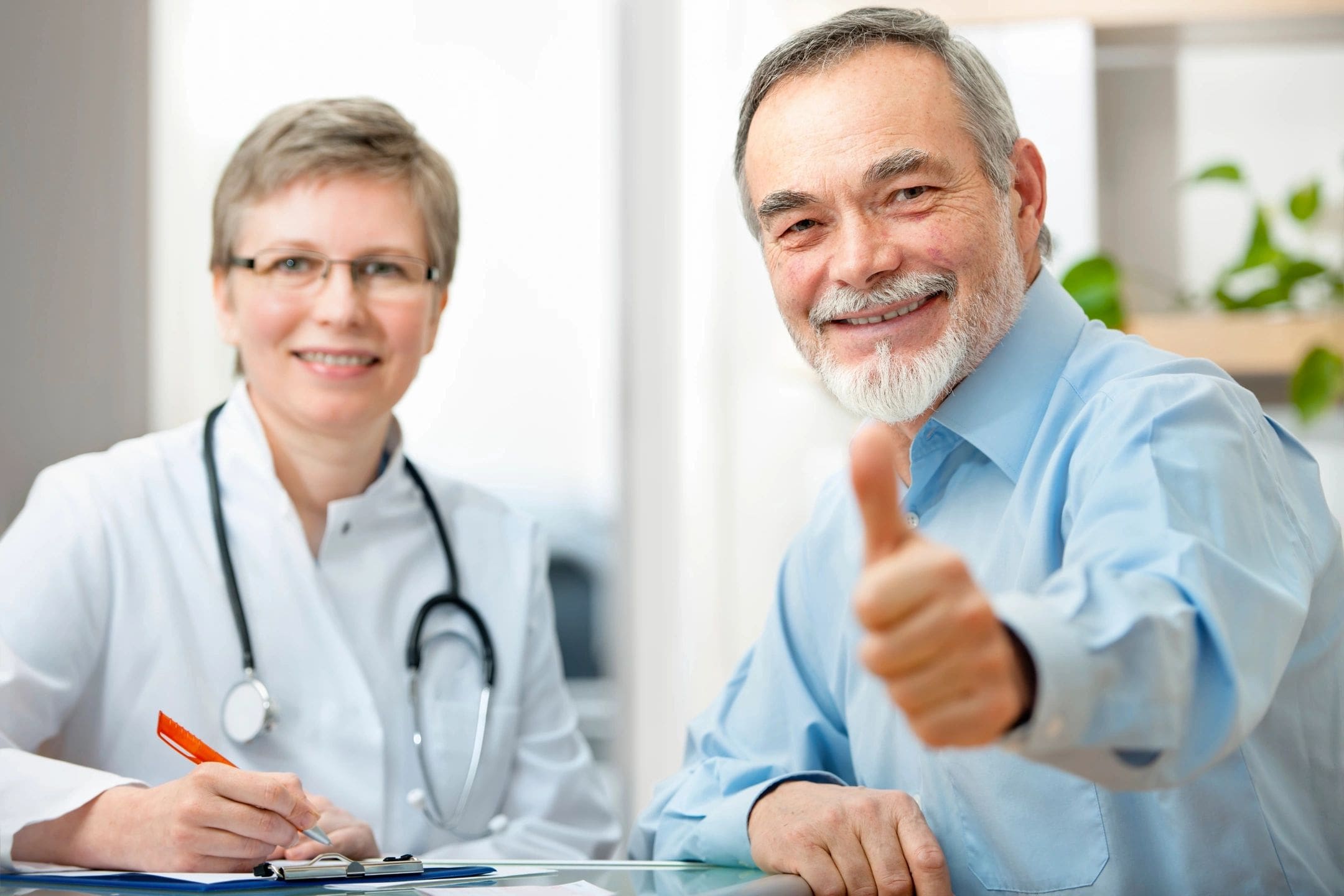 Senior patient giving thumbs up with doctor