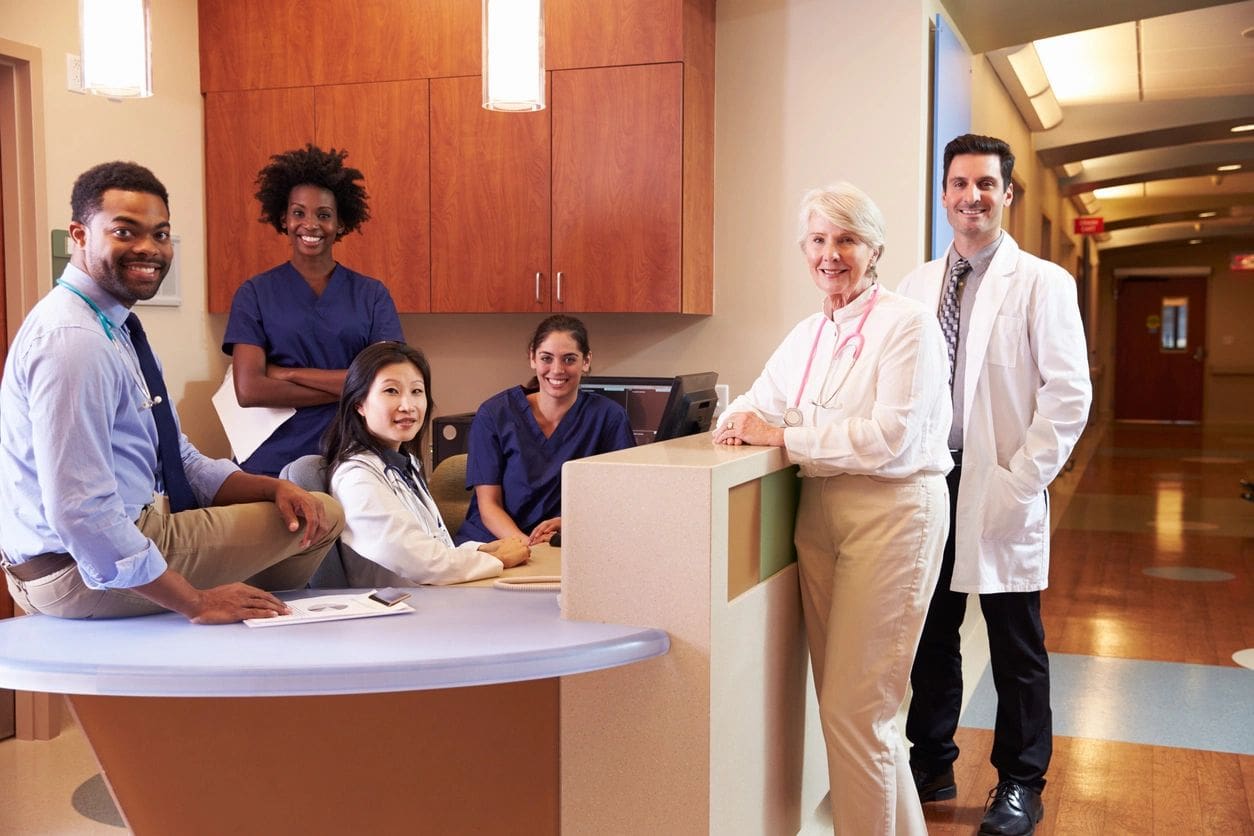 Smiling healthcare team at nurses' station