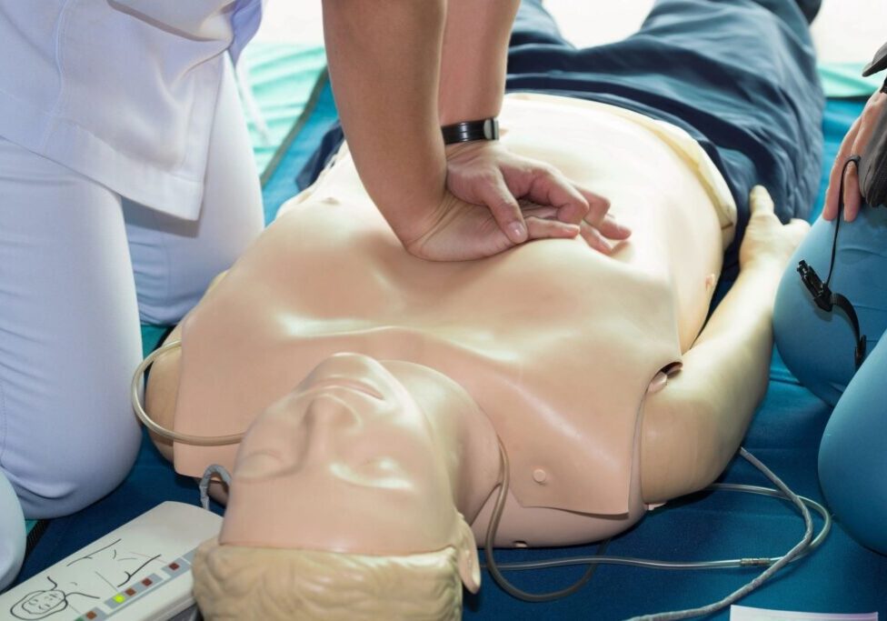 A person is performing cpr on an infant dummy.
